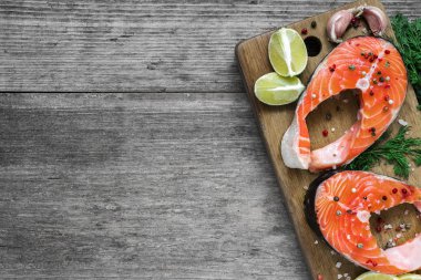 herb, limon ve karabiber ahşap kesme tahtası üzerinde Çiğ somon steak. sağlıklı diyet yiyecek. Üstten Görünüm