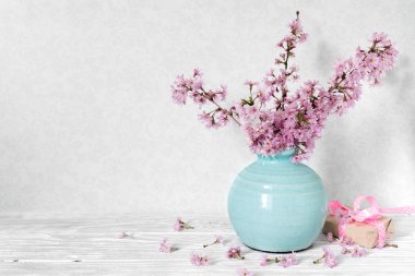 Natürmort çiçek açan, kokulu kiraz şube veya sakura hediye kutusu beyaz tablo ile bir vazoda