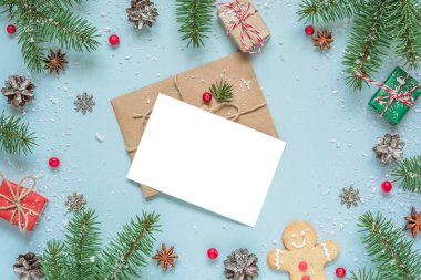 Köknar ağacı dalları, süslemeler, böğürtlenler, zencefilli ekmek ve çam kozalaklarından yapılmış çerçevedeki Noel tebrik kartı