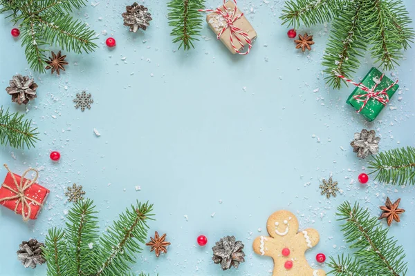 전나무 가지, 장식용 열매, 열매, 진저브레드 및 소나무 원추체로 만든 크리스마스 틀 이 푸른 배경 위에 있다 — 스톡 사진