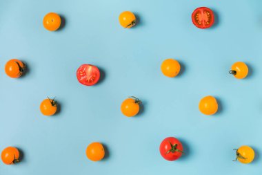 Mavi arka planda sarı ve kırmızı domateslerin renkli desenleri. düz yat