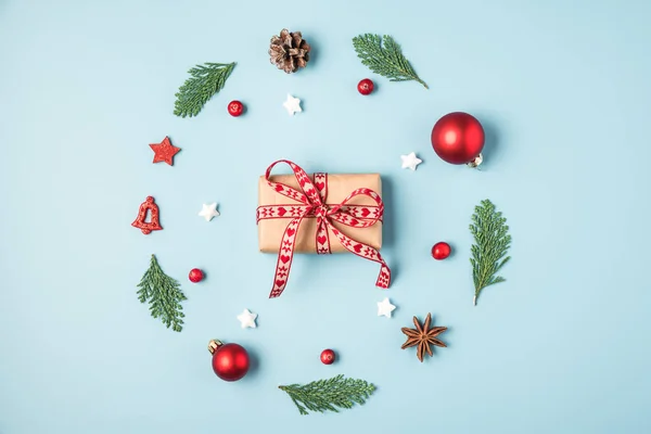 Composición navideña. Corona de Navidad hecha de ramas de abeto, decoraciones, bayas con caja de regalo sobre fondo azul —  Fotos de Stock