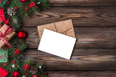 Noel ve Yeni Yıl tebrik kartı. Köknar ağacı dalları, hediye kutuları, kırmızı bayram süslemeleri.