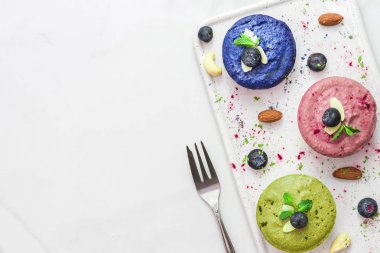 Çiğ vejetaryen renkli pastalar, kibrit, acai, mavi spirulina ve bezelye çayı, taze böğürtlen, nane, fındık