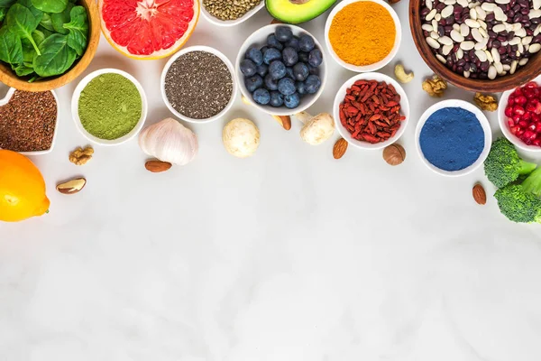 Comida vegana saludable selección de alimentos limpios: frutas, verduras, semillas, superalimentos, nueces, bayas sobre fondo de mármol blanco —  Fotos de Stock