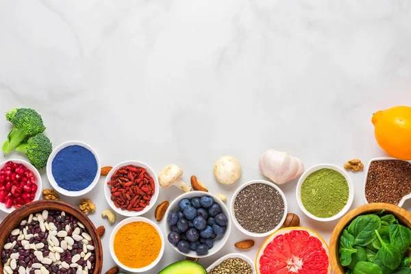 Asortyment zdrowej żywności wegańskiej na tle marmuru. warzywa, matcha, acai, kurkuma, owoce, jagody — Zdjęcie stockowe