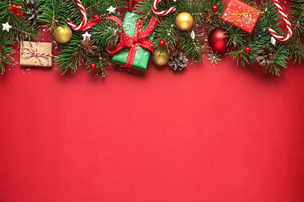 Karácsonyi vagy boldog új évet összetétele fenyő ágak, ajándékdobozok és nyaralás dekorációk piros alapon — Stock Fotó