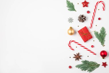 Noel kompozisyonu. Firavun ağacı dalları, hediye kutuları, süslemeler, şeker, beyaz arka planda çam kozalakları. en üstteki görünüm
