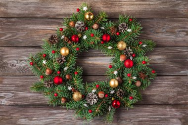 Köknar ağacından yapılmış Noel çelengi ve köy ahşap masasında tatil süslemeleri..