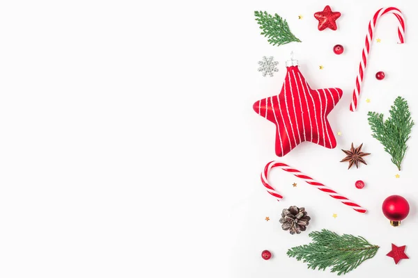 크리스마스 배경. 전나무 가지들, 빨간 장식들, 사탕들, 소나무 원추형의 하얀 배경. 맨 위 사진 — 스톡 사진