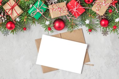 Noel veya Yeni Yıl tebrik kartı, içinde köknar ağacı dalları, bayram süslemeleri ve hediye kutuları olan.