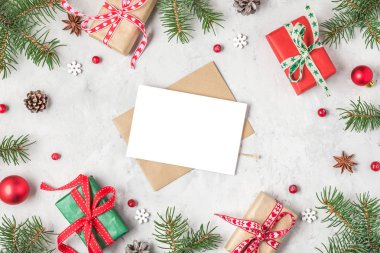 Köknar ağacı dalları, bayram süslemeleri ve hediye kutularından yapılmış çerçevede Noel veya Mutlu Yıllar tebrik kartı