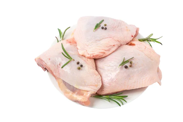 Tabakta çiğ tavuk kalçası eti ve beyaz arka planda izole edilmiş baharatlar.