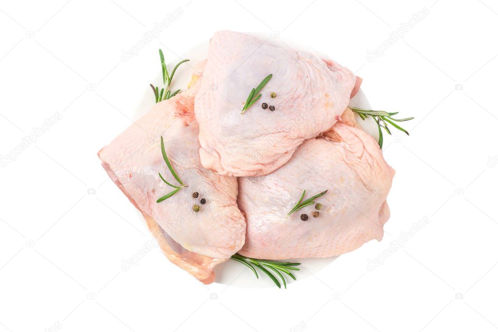 Raw chicken hip meat in a plate with herbs and spices isolated on white background