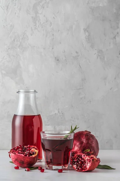 Zumo de granada con frutas frescas de granada y romero sobre mesa de mármol. Orientación vertical. Bebida saludable — Foto de Stock