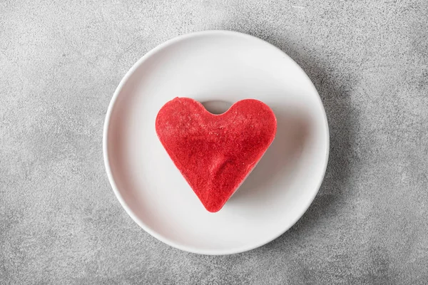 Postre de San Valentín. corazón en forma de pastel vegano crudo en un plato. comida deliciosa saludable. vista superior — Foto de Stock