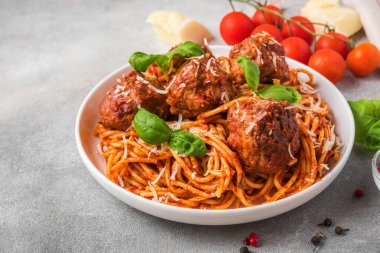Köfteli spagetti makarna, domates sosu, parmesan peyniri ve fesleğen. İtalyan yemeği. Kapat. seçici odak
