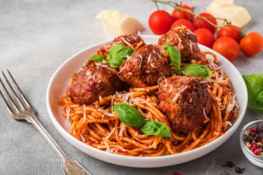 Köfteli makarna, domates sosu, parmesan peyniri ve çatallı fesleğen. İtalyan yemeği. Kapat.