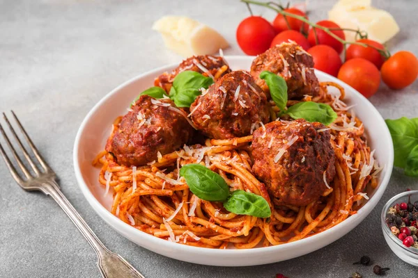 Köfteli makarna, domates sosu, parmesan peyniri ve çatallı fesleğen. İtalyan yemeği. Kapat.