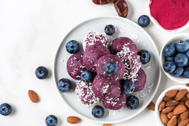 Çiğ vejetaryen ev yapımı tatlı. Yabanmersini ve acai enerji topları ya da taze böğürtlenli ısırıklar. Üst Manzara. Sağlıklı vejetaryen atıştırmaları
