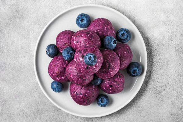 Energy balls or energy bites made of blueberries, acai, dates and nuts. Healthy vegan diet snacks dessert. top view