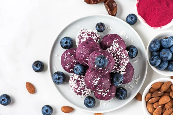 Raw vegan homemade dessert. Blueberry and acai energy balls or bites with fresh berries. top view. Healthy vegan snacks