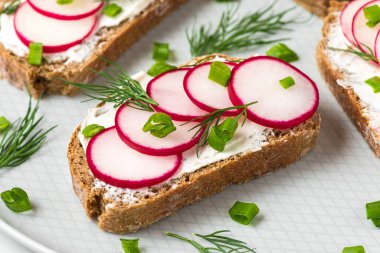 Yumuşak peynirli, soğanlı ve dereotlu turp tostu. Sağlıklı beslenme atıştırmalıkları. Kapat.