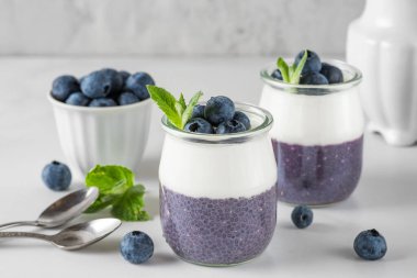 Vejetaryen hindistancevizli yoğurtlu yaban mersinli puding ve sağlıklı bir diyet kahvaltısı için naneli taze böğürtlen. Kapat.