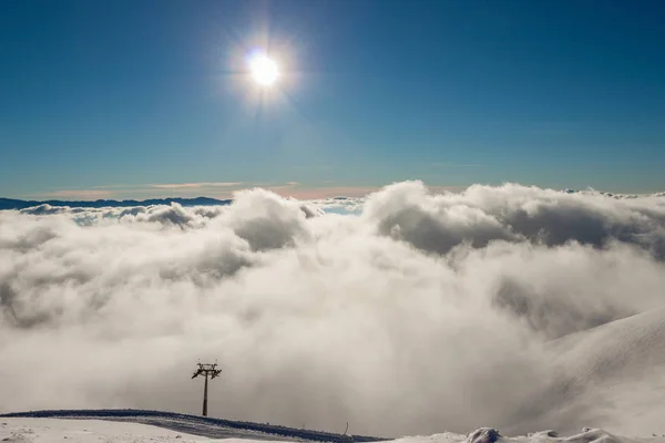 Low clouds in the mountains and the sun