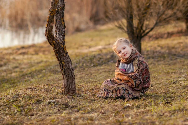 Chica sentada en la hierba de primavera — Foto de Stock