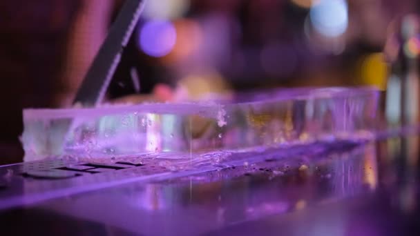 Бармен пилит лед в баре пилой — стоковое видео