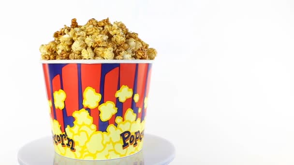 Karamelový popcorn se otočí na bílém pozadí. Široký záběr — Stock video