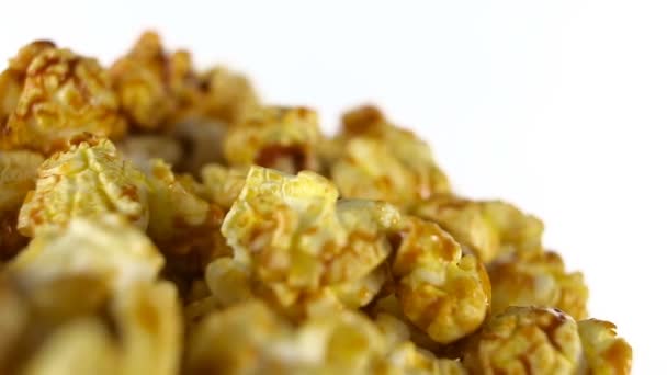 Caramel popcorn rotates on a white background. Super close up shot — Stock Video