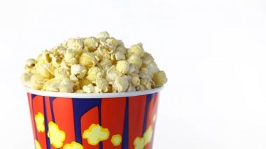 Tuzlu popcorn beyaz bir arka plan üzerinde döner. Orta atış