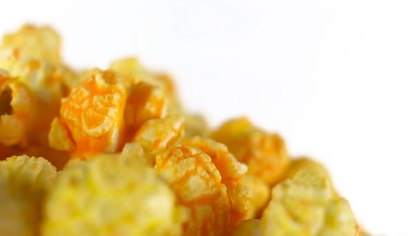 Cheese popcorn rotates on a white background. Super close up shot — Stock Video