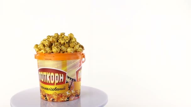 Popcorn karamel draait op een witte achtergrond. Brede shot — Stockvideo