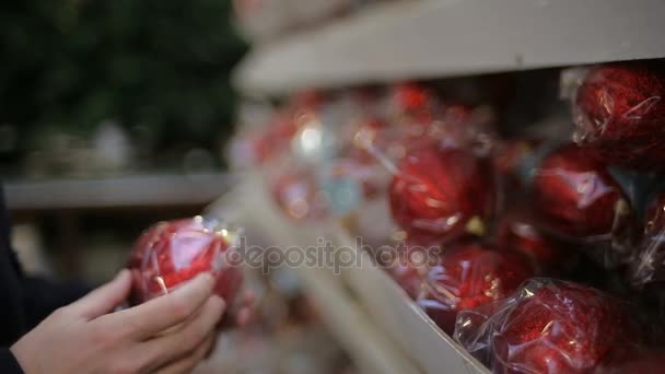 El hombre elige decoraciones navideñas en una tienda — Vídeos de Stock