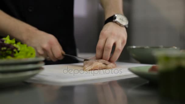 Шеф-повар режет филе индейки на доске для резки — стоковое видео