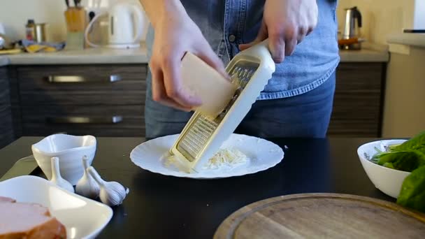 Os chefes de mãos esfregam o queijo em um ralador. Café da manhã caseiro — Vídeo de Stock