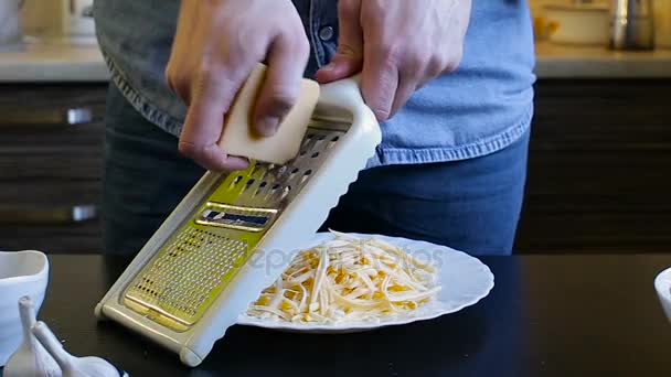 Os chefes de mãos esfregam o queijo em um ralador. Café da manhã caseiro — Vídeo de Stock