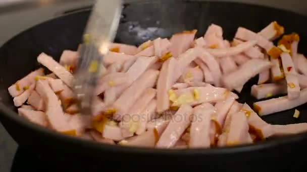 Seno y ajo se fríen en una sartén en la cocina — Vídeo de stock