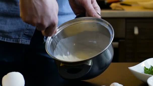 Μαγειρέψτε τα χέρια μαστίγωμα κρέμα και τα αυγά σε μια κατσαρόλα — Αρχείο Βίντεο