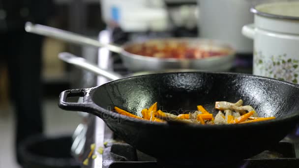 Kuchař smažení zeleniny a masa v wok v kuchyni — Stock video