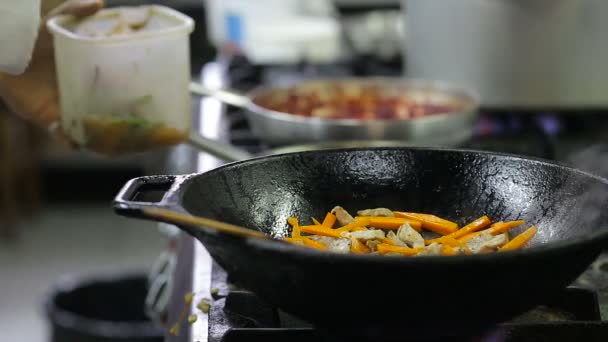 Kuchař smažení zeleniny a masa v wok v kuchyni — Stock video