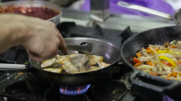 Chef freír verduras y carne en un wok en la cocina — Vídeo de stock