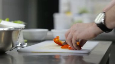 Şef mutfakta sebze doğruyor.