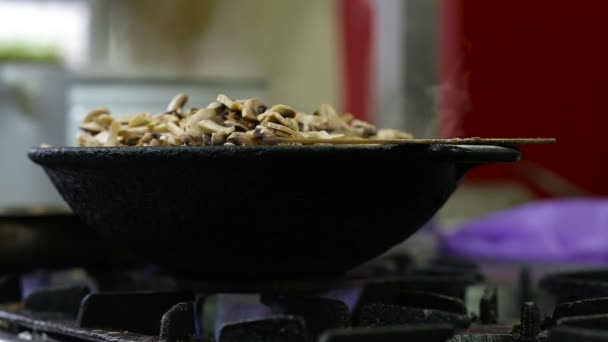 Los hongos se fríen en un wok en la cocina — Vídeo de stock