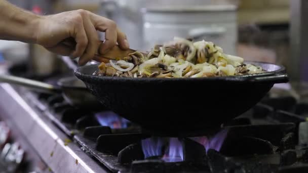 Les champignons sont frits dans un wok dans la cuisine — Video