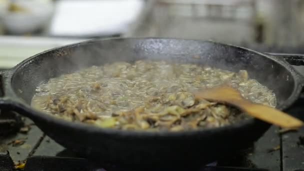 Paddestoelen zijn gebakken in een wok in de keuken — Stockvideo