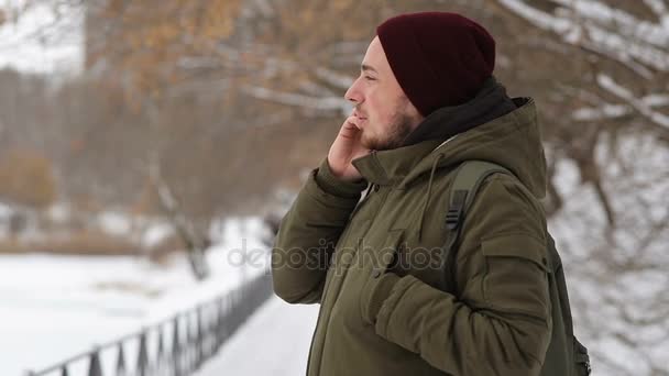 Человек разговаривает по телефону в переулке зимой — стоковое видео